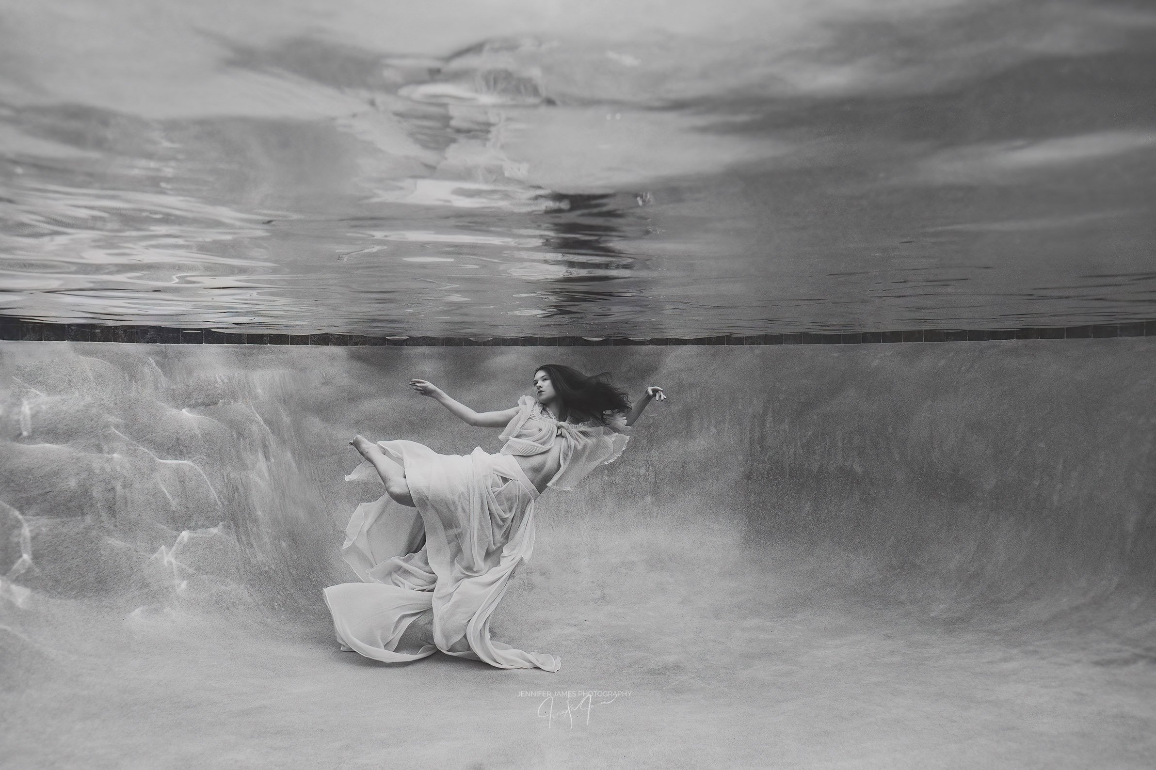 A woman dancing below the surface of the water wearing a full, flowing skirt in Saint John's, Florida at our underwater photography studio.